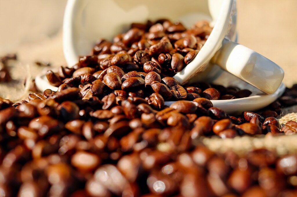 カップからこぼれるコーヒー豆