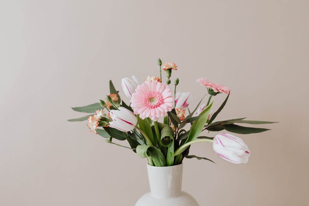 薄ピンクの花束が花瓶に飾られている